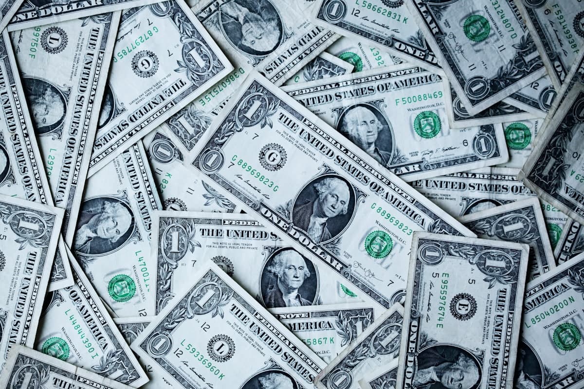 A scattered pile of US one-dollar bills, representing the range of small business website costs.